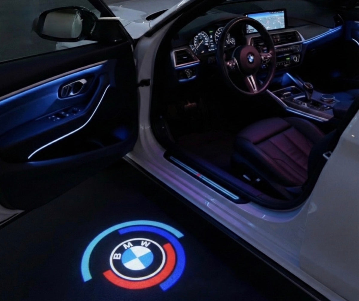 LED projektor loga do dverí – štýl 14: Okrúhle logo BMW s oblúkom vo farbách M; projekcia na zem vedľa otvorených dverí vozidla