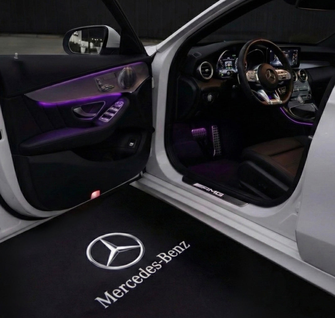 LED-instapverlichting – Stijl 1: Ster met Mercedes-Benz-letters, geprojecteerd op de grond naast een geopende autodeur